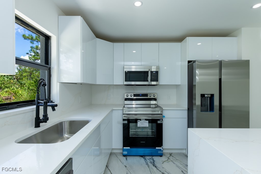 2019 Hamilton Avenue Alva, FL 33920 - Photo 8 of 50 a kitchen with stainless steel appliances a stove a sink a microwave a refrigerator and cabinets