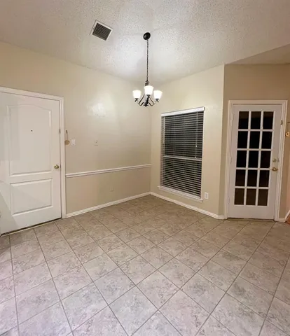 an empty room with windows and cabinet