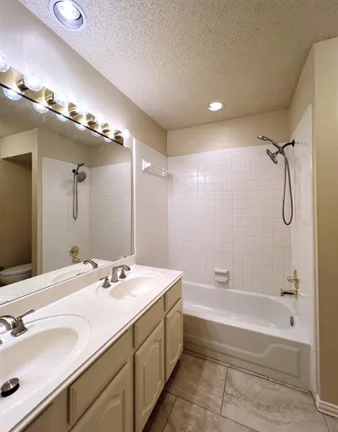 a spacious bathroom with a tub sink shower and mirror