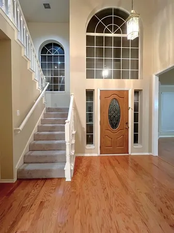 a view of a hallway with wooden floor and a large window