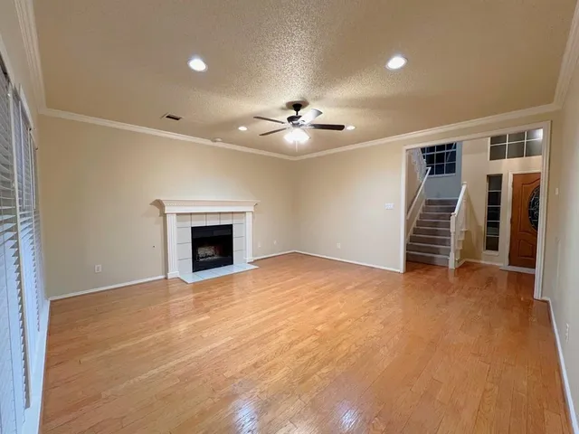 an empty room with a fireplace and a ceiling fan