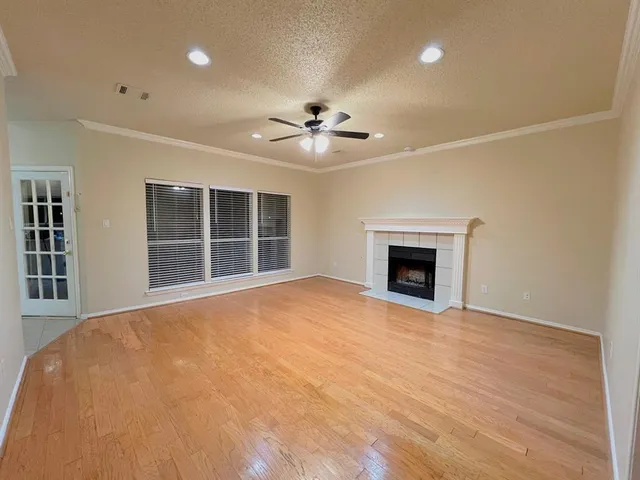 a view of an empty room with a fireplace and a window