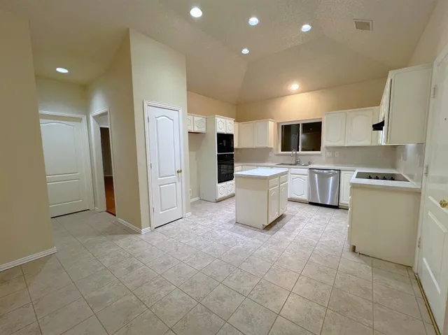 a view of kitchen with stainless steel appliances granite countertop a refrigerator and a stove top oven