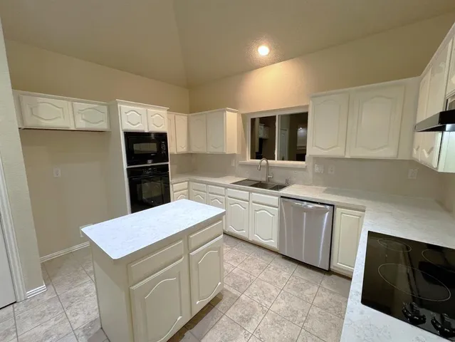 a kitchen with a sink a stove a refrigerator a microwave and cabinets