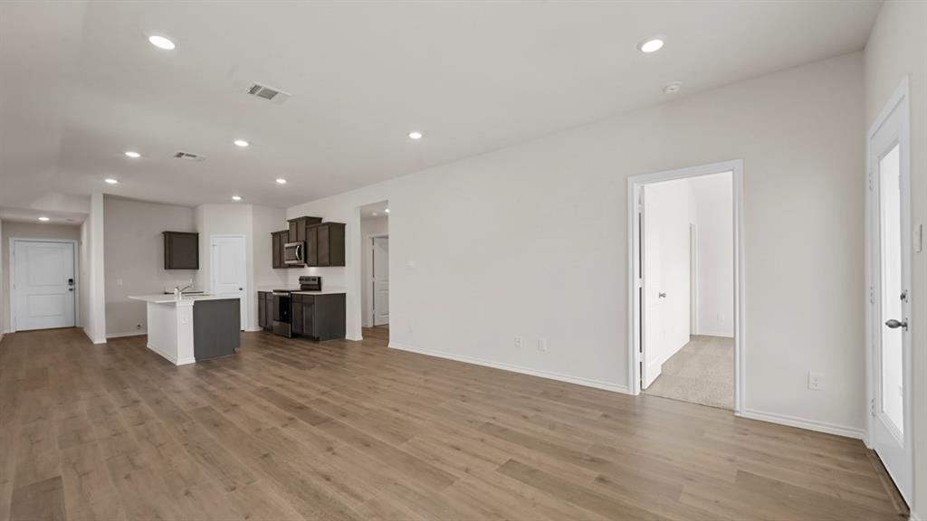 1663 Blaire Drive Tyler, TX 75704 - Photo 11 of 26 Spacious open-concept living area featuring wood-finish flooring, recessed lighting, and a kitchen island with seating