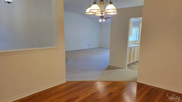 an empty room with a window and ceiling fan