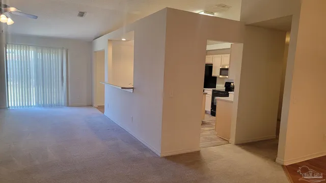 a view of a hallway with closet and a bathroom