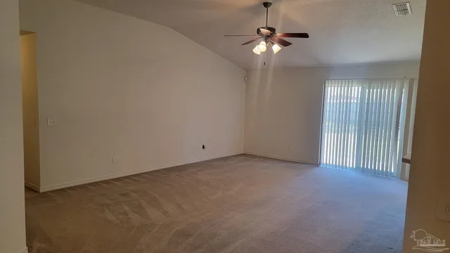 an empty room with fan and windows