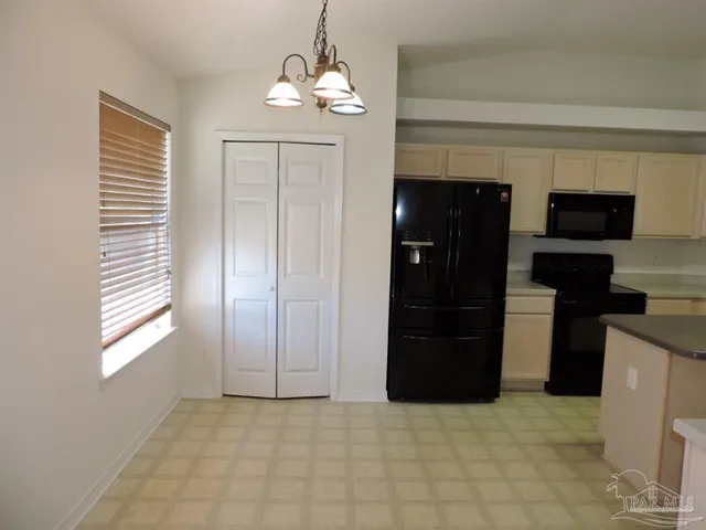 a view of kitchen with refrigerator and window