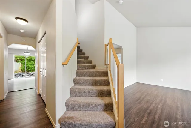 a view of a hallway with wooden floor and staircase