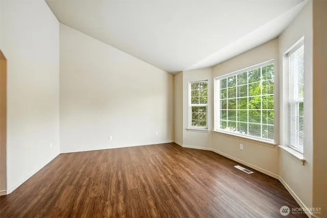 a view of a room with wooden floor and windows