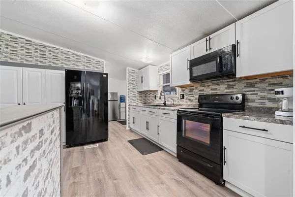 a kitchen with stainless steel appliances a stove microwave and refrigerator