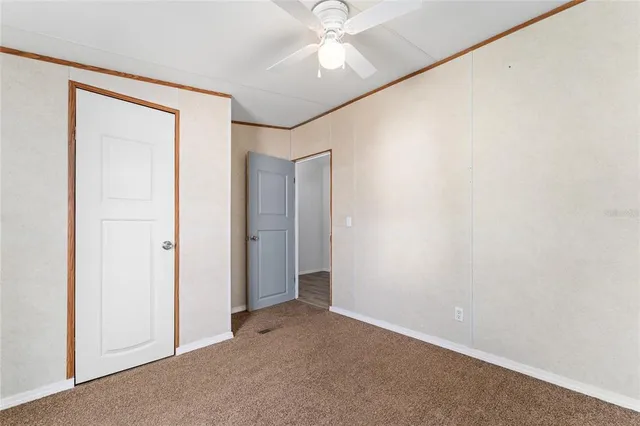 an empty room with a ceiling fan and a window