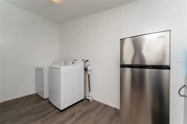 a utility room with wooden floor washer and dryer