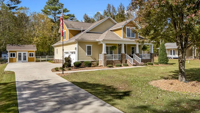 a front view of house with yard and trees in the background