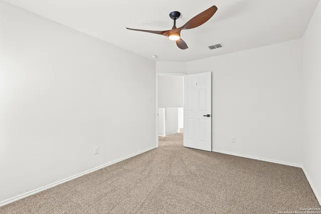 a view of a room with a ceiling fan and window