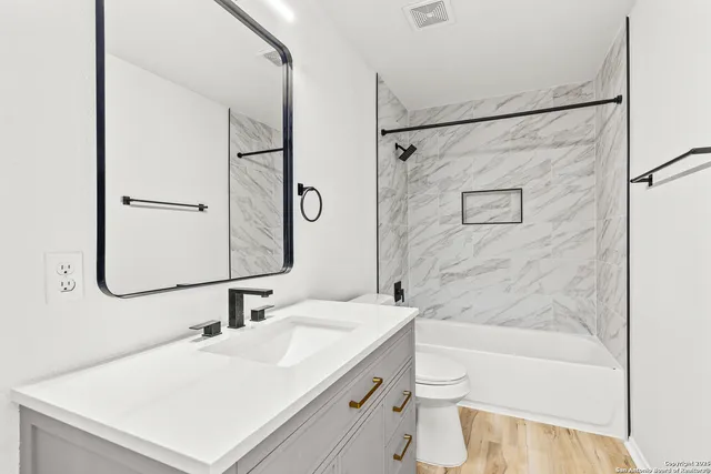 a bathroom with a sink a toilet and shower