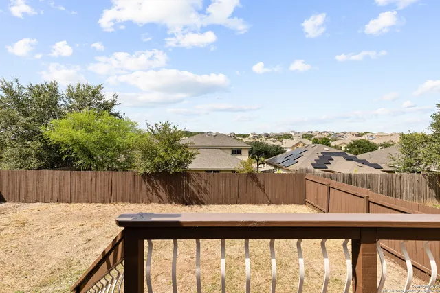 a view of a roof deck with couches and wooden fence