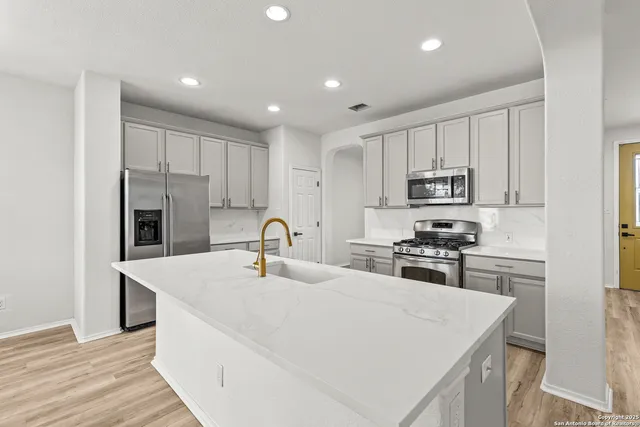 a kitchen with stainless steel appliances granite countertop a sink stove and refrigerator