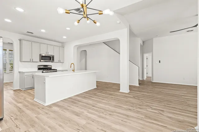 a view of kitchen with refrigerator microwave and stove with wooden floor