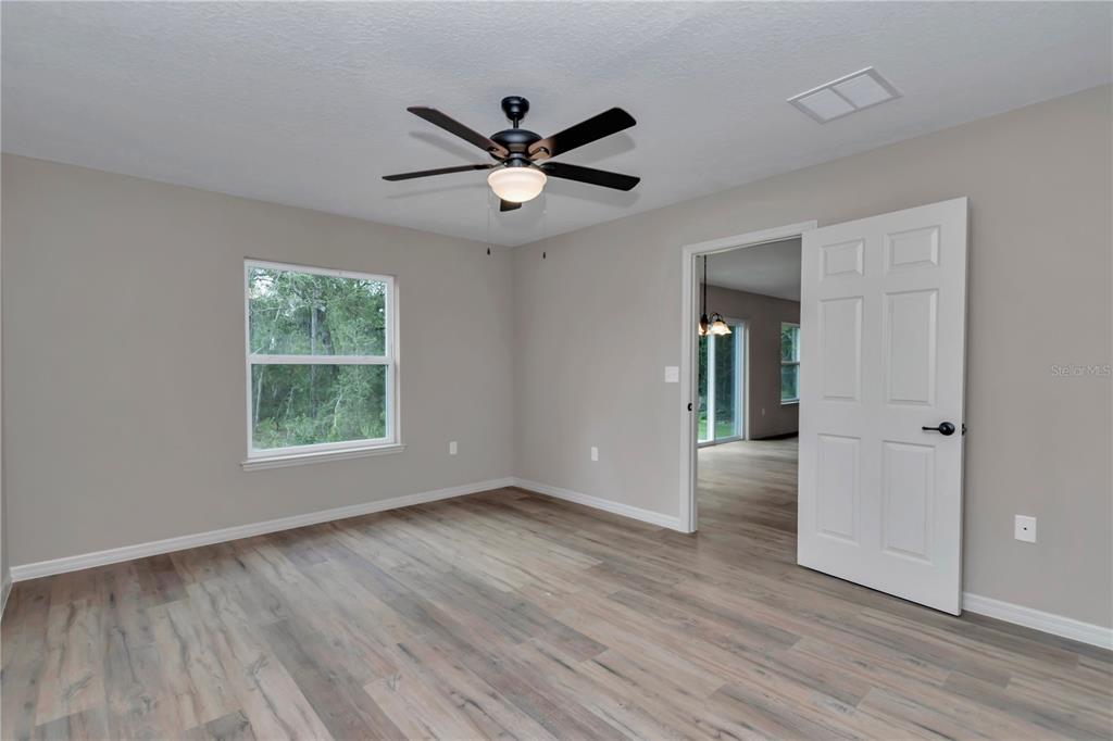 12841 Southwest 83rd Terrace Ocala, FL 34473 - Photo 16 of 31 a view of an empty room with wooden floor and a window