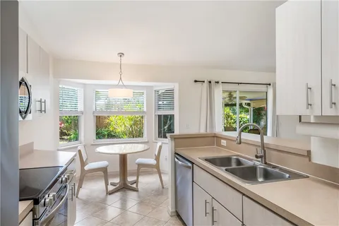 a kitchen with granite countertop a sink and a refrigerator