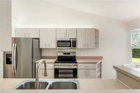 a kitchen with stainless steel appliances a refrigerator sink and stove