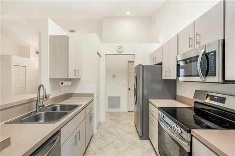 a kitchen with stainless steel appliances a sink stove and refrigerator