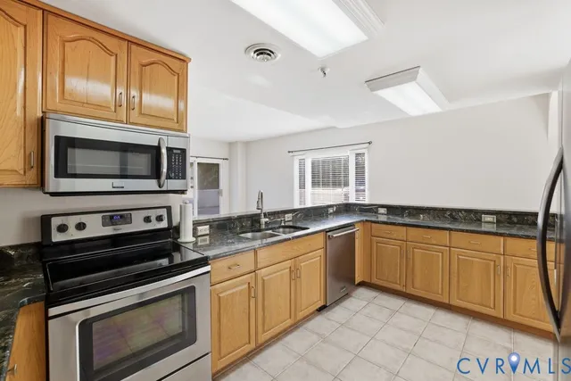 a kitchen with granite countertop a sink and white cabinets