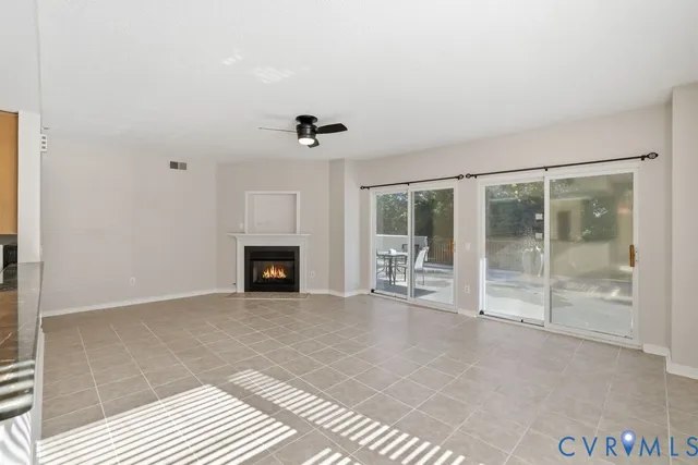 a view of an empty room with windows and a fireplace