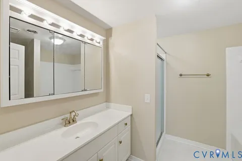 a bathroom with a double vanity sink and mirror with shower