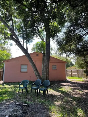 a backyard of a house with table and chairs