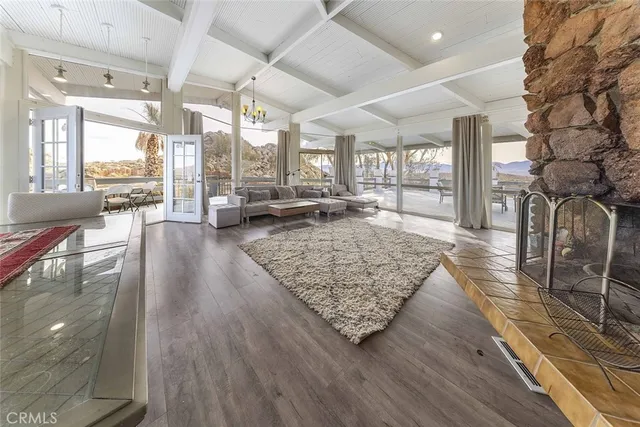 a living room with lots of furniture wooden floor and a table