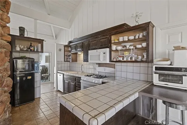 a kitchen that has a lot of cabinets in it and wooden floors