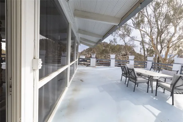 a view of a porch with chairs and floor to ceiling window