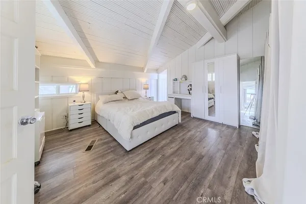 a spacious bedroom with a bed a couch and a large window