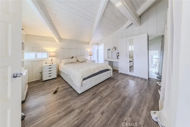 a spacious bedroom with a bed a couch and a large window