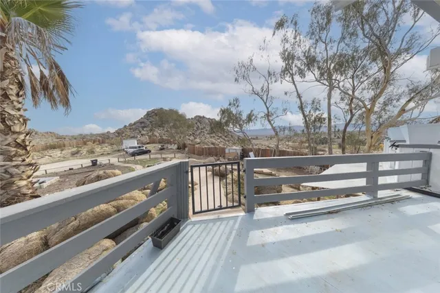 a view of a patio with table and chairs with wooden floor and fence