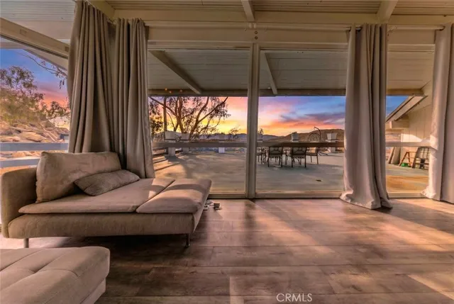 a living room with furniture and a floor to ceiling window