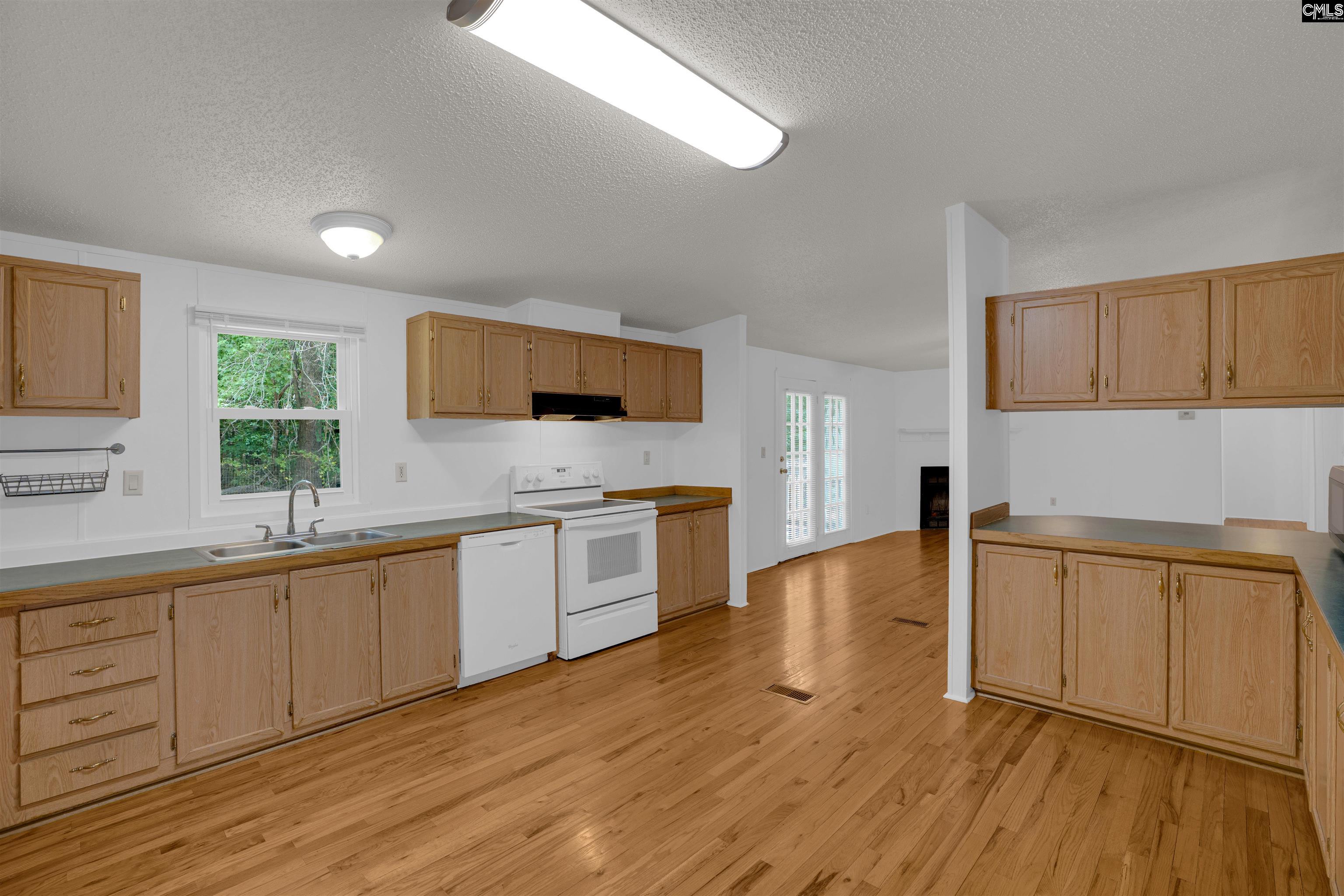 304 Cooper Road Blythewood, SC 29016 - Photo 7 of 29 a large kitchen with stainless steel appliances granite countertop a sink a stove a microwave a counter space and cabinets