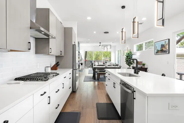 a view of a patio with couches table and chairs with wooden floor and fence