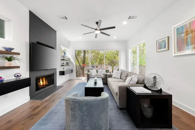 a living room with fireplace furniture and a large window