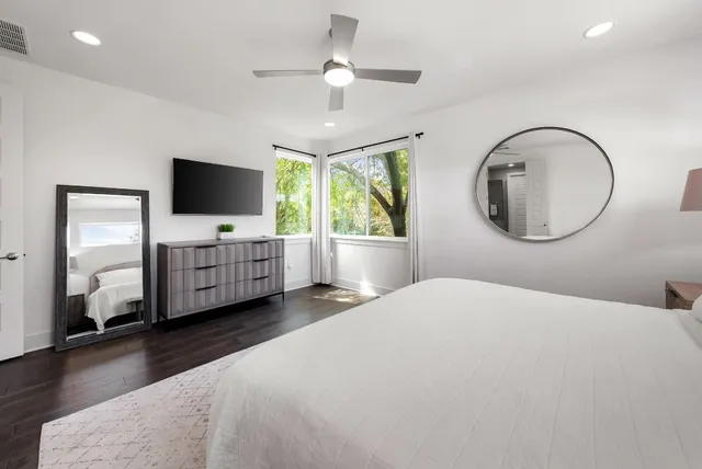 a bedroom with a bed mirror and window