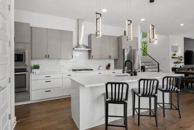 a kitchen with white cabinets and stainless steel appliances