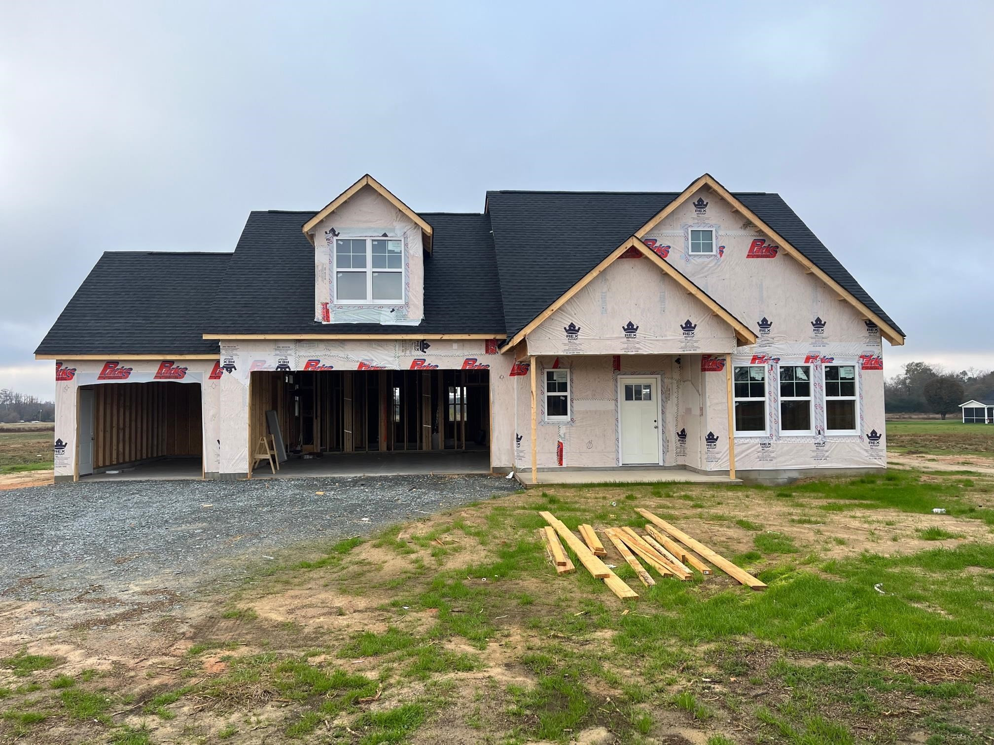 a view of a house with a big yard and large trees