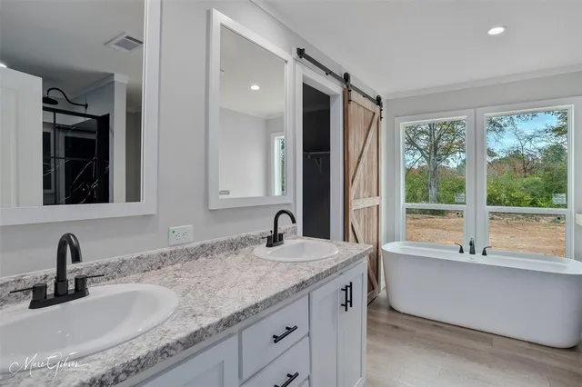 a bathroom with a granite countertop sink and a large mirror