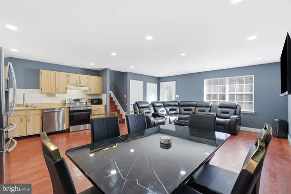 a living room with stainless steel appliances furniture dining table and a window