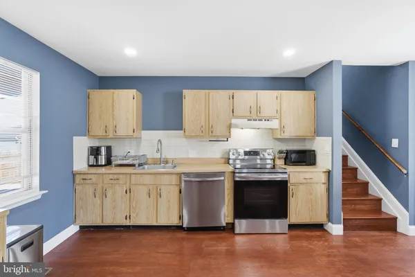 a kitchen with kitchen island granite countertop a stove and a sink