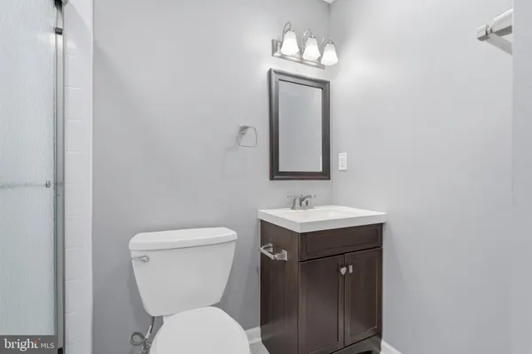 a bathroom with a toilet a sink and mirror
