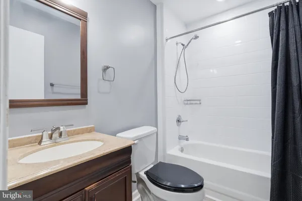 a bathroom with a granite countertop sink toilet a mirror and shower